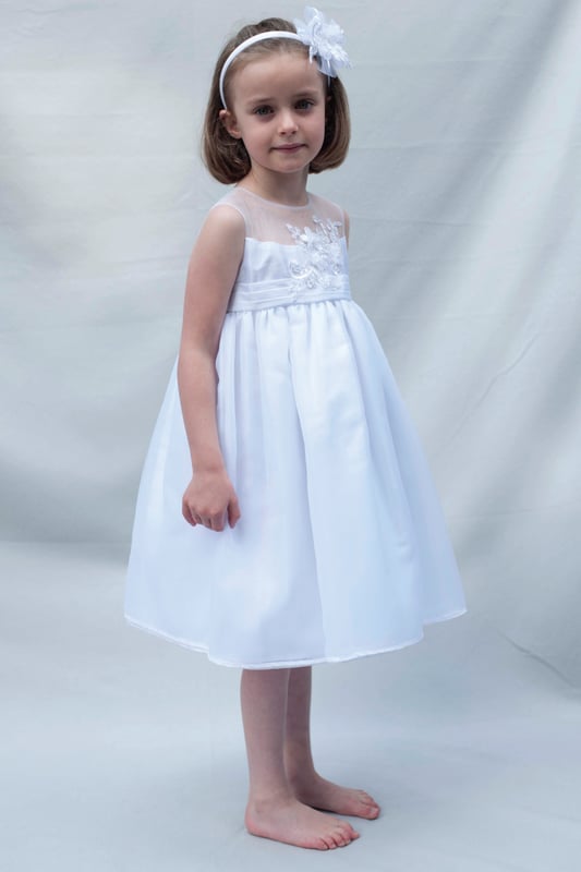 ROSIE by Heritage, is another one of our stunning special occasion dresses using fabric that has been sourced from Japan.
It has a delicate organza fabric section over the shoulders and around the neck, making it almost invisible from a distance.
The body is made from our popular 'mock silk' with pin tucks around the waist. We then added a guipure lace flower shape panel over the top that has been hand finished with organza flowers and pearl beads.
The skirt has net layers underneath creating a lovely full princess like shape. Perfect for twirling at any given moment, as long as they're not walking down the Aisle behind the bride at the time.  Perfect for parties though ;)
The back of the dress has a long sash to tie a large bow and has a back zip fastening.
It's lined in 100% soft cotton lawn fabric so it is soft against the child's skin and keeps them cool.
The dress comes to you on a padded satin hanger and protected in a Heritage keepsake bag.
This beautiful ROSIE white dress is ideal for Christenings, Baptisms, Flower girl dress or any other special occassion! Team it up with our VALENTINA cardigan in white and you're ready to wow your friends and relatives! Kodak moment
Outer - 100% Polyester (mock silk and Organza)
Lining - 100% cotton
Hand wash or Dry clean only