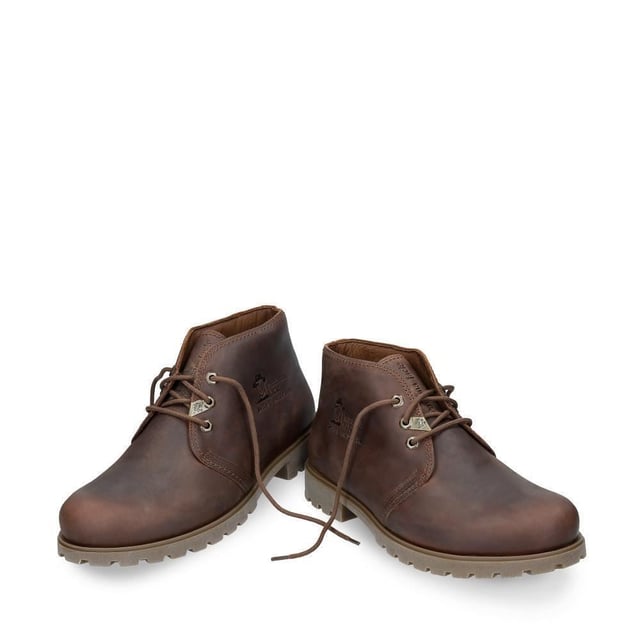 Treten Sie stilvoll hervor mit dem Panama Jack Bota Panama C10 Herren-Chukka-Stiefel. Gönnen Sie sich unvergleichlichen Komfort und Stil mit dem Panama Jack Bota Panama C10 Herren-Chukka-Stiefel. Diese Stiefel bestehen aus hochwertigem, wasserdichtem Lederobermaterial und exquisiten Nahtdetails und bieten sowohl Haltbarkeit als auch Raffinesse. Das Panama Jack-Branding auf der Außenseite verleiht einen Hauch von Prestige und zeigt Ihre Affinität zu hochwertiger Handwerkskunst. Diese Stiefel verfügen über ein Schnürdesign mit einer praktischen 3-Loch-Schnürung vorne und ermöglichen ein einfaches An- und Ausziehen sowie eine verstellbare Passform für maximalen Komfort. Im Inneren sorgt eine herausnehmbare, anatomisch geformte Einlegesohle für hervorragenden Halt und kann bei Bedarf mühelos durch Ihre eigenen Einlagen ersetzt werden. Das Lederfutter umhüllt Ihren Fuß mit weichem Komfort und verbessert das Gesamtgefühl. Diese Stiefeletten sind für den täglichen Gebrauch konzipiert und verfügen über eine rutschfeste Naturkautschuk-Außensohle, die sowohl Flexibilität als auch Haltbarkeit bietet. Ganz gleich, ob Sie durch Stadtstraßen oder auf Landwegen navigieren, Sie können sich darauf verlassen, dass diese Stiefel zuverlässige Traktion und Stabilität bieten. Hauptmerkmale: Premium-Konstruktion: Diese Stiefel sind aus wasserfestem, geöltem Nappaleder gefertigt und strahlen zeitlose Eleganz und Haltbarkeit aus. Stilvolle Details: Die Nahtdetails verleihen dem klassischen Chukka-Stiefel-Design einen Hauch von Raffinesse und verleihen Ihrem Look einen subtilen Charme. Rutschfest: Die flexible und langlebige TPU-Gummisohle sorgt für rutschfeste Traktion auf verschiedenen Oberflächen und sorgt für Stabilität bei jedem Schritt. Bequeme Passform: Mit einem flachen Ankle-Boot-Design und einer Schafthöhe von 14 cm bieten diese Stiefel eine bequeme und dennoch bequeme Passform, die sich perfekt für den ganztägigen Tragekomfort eignet. Luxuriöse Innenausstattung: Das Futter aus Vitello-Leder erhöht den Komfort und die Atmungsaktivität und sorgt bei jedem Tragen für ein angenehmes Tragegefühl. Hergestellt in Spanien: Diese in Spanien fachmännisch gefertigten Stiefel zeugen von höchster Handwerkskunst und Liebe zum Detail. Absatzhöhe: 3 cm