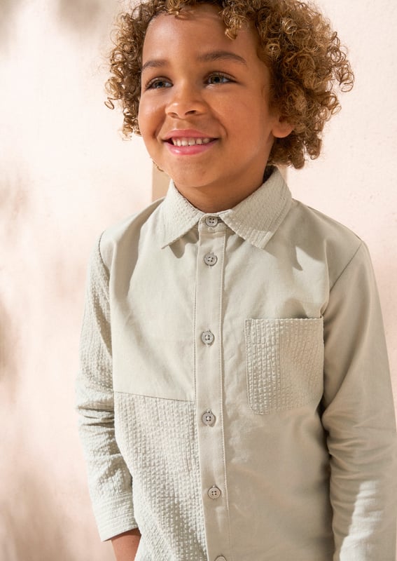 An A&R twist on the classic shirt. A clever mix of cut and sew textured and plain panels in soft sage green. this long-sleeved shirt features a classic silhouette and a button placket. A versatile piece that can be dressed with chinos or shorts and worn w.