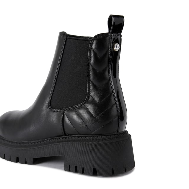 This Carvela Ace Chelsea ankle boot features a black upper with chevron overstitch quilting at the back of the ankle. There is a crystal stud at the back of the ankle with a small patent pull tab.