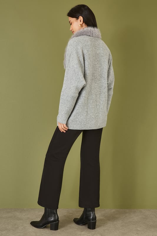 This cute cardi is perfect for cosying up this winter - In a soft marl knit with buckle fastening in the front and faux fur detachable collar. Style with jeans and a roll neck jumper - With boots or trainers for a casual off duty look.