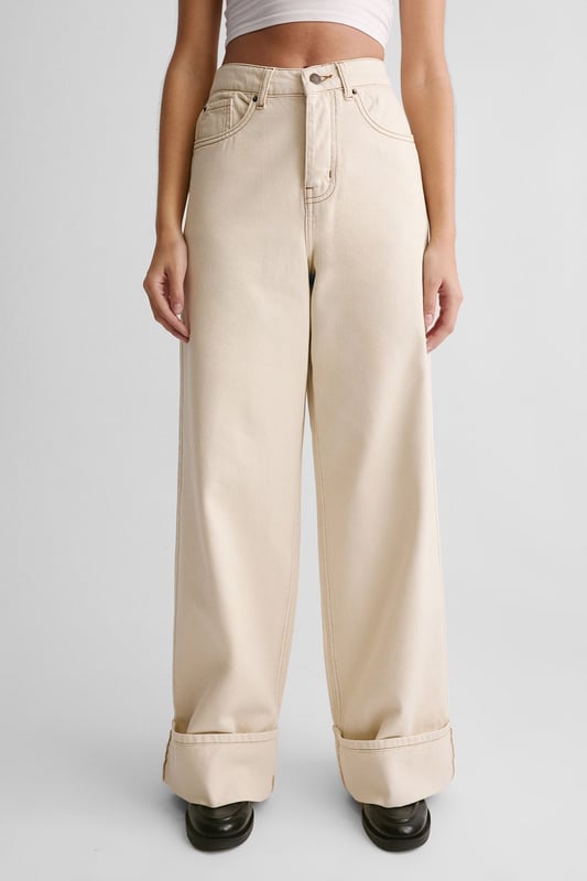 Wide-leg silhouette for a relaxed, on-trend look
        Distinctive turn-up cuffs adding a stylish twist
        High-waisted design for a flattering fit
        Classic five-pocket styling for practicality
        Versatile denim fabric suitable for various casual occasions
    
    The Denim Turn Up Jean from NastyGal presents a fresh take on a wardrobe staple. These jeans manifest a perfect blend of comfort and style, ideal for the fashion-forward individual seeking a versatile piece. The wide-leg silhouette paired with the high-waisted design creates a striking profile, while the turn-up cuffs add a touch of casual sophistication. Style these jeans with a fitted white vest top and chunky loafers for an effortlessly cool daytime look. For a more laid-back vibe, pair with a loose-fitting tee and trainers. These jeans are perfect for casual outings, family gatherings, or relaxed weekends about town. Their adaptable nature allows for easy transition from day to night - simply swap your flats for a pair of statement heels and add a blazer for an evening-ready ensemble. The Denim Turn Up Jean is a must-have piece that will quickly become a cornerstone of your casual wardrobe.