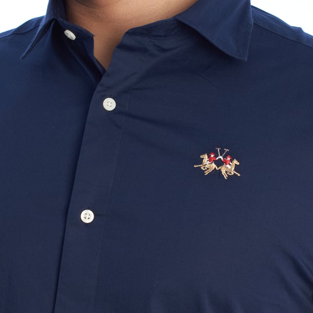 Camisa clásica de hombre La Martina. 

Una prenda imprescindible en el armario masculino que equilibra a la perfección estilo y funcionalidad. Esta camisa de La Martina destaca por su diseño atemporal y detalles sofisticados que reflejan la esencia de la marca.

Detalles:

- Camisa de manga larga con cierre frontal de botones.
- Diseño de corte ajustado que se adapta perfectamente al cuerpo.
- Confeccionada en algodón de alta calidad, ligero y transpirable.
- Logotipo de La Martina bordado en el pecho.
- Puños ajustables con doble botón para un mejor ajuste.
- Cuello clásico que se adapta a cualquier look.
- Dobladillo curvado que facilita su uso por dentro o fuera del pantalón.
- Etiqueta decorativa en la parte inferior que refuerza la autenticidad de la marca.
- Corte recto que asegura un calce cómodo y estilizado.

Una camisa manga larga versátil que combina elegancia y comodidad, ideal para ocasiones formales o para elevar un look casual. Perfecta para quienes valoran la calidad y los detalles de diseño exclusivos.
 Composición: 97% Algodón, 3% Poliéster
 Cuidados:
- Lavar máximo a 30°C en ciclo delicado.
- No usar lejía ni blanqueadores.
- Planchar a baja temperatura, preferiblemente del revés.
- No usar secadora.