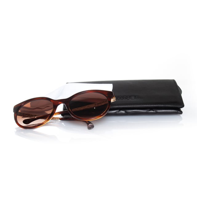 VINTAGE, RRP AS NEW
Chanel, round tortoise sunglasses with metal Chanel cut out temples in gold. The item is in good condition. The lenses have very light scratches and The temples are slightly apart (need adjustment). Comes with case and dust cloth.
 • CONDITION: good

• CODE: 5440

• MEASUREMENTS: height lens 5,5 cm, width lens 6 cm, width frame 14 cm

• MATERIAL: plastic, metal

• COLOR: brown, gold