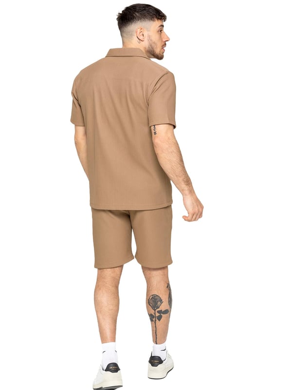 Elevate your summer style with our Enzo Milano Men's Outfit Set, including a textured ribbed revere shirt and relaxed fit shorts. Experience ultimate comfort with a button fastening and adjustable drawstring waistband, while looking effortlessly stylish with a revere collar and single back welt pocket. Made with premium fabric, this set is perfect for any occasion.