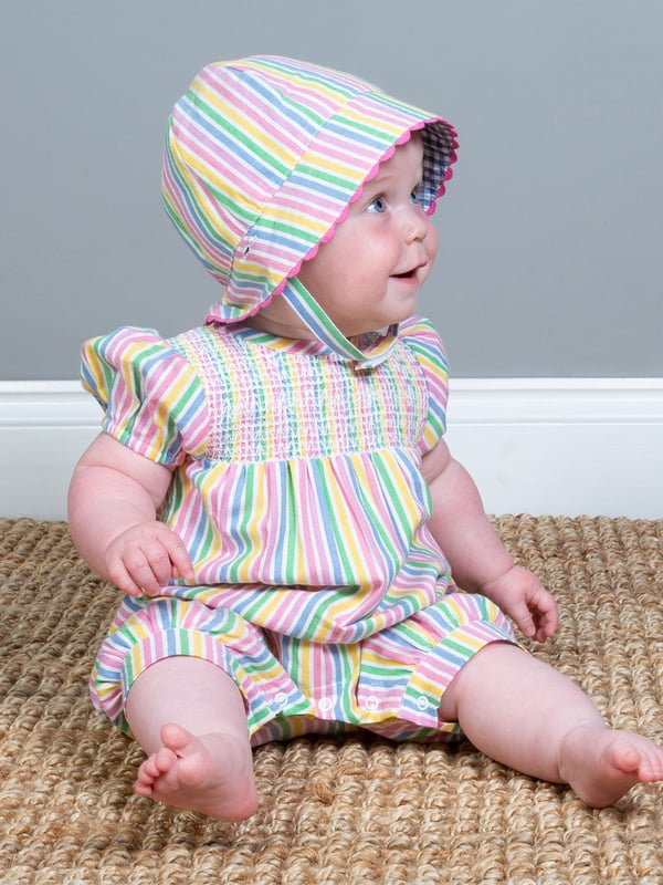 Sweetness and light! This colourful and breathable romper is perfect for sunny days. With soft gathered sleeves and smocking detail on the chest, it is both practical and pretty, and the perfect option for little crawlers, walkers and wrigglers! Match with the sweet stripe sun hat for the sweetest style this season.
