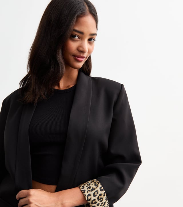 Elevate your style with our sleek Black Contrast Animal Edge to Edge Blazer. Stand out with its unique animal print contrast, perfect for the fashion-forward woman. This versatile blazer can be dressed up or down, making it a stylish addition to any wardrobe.
