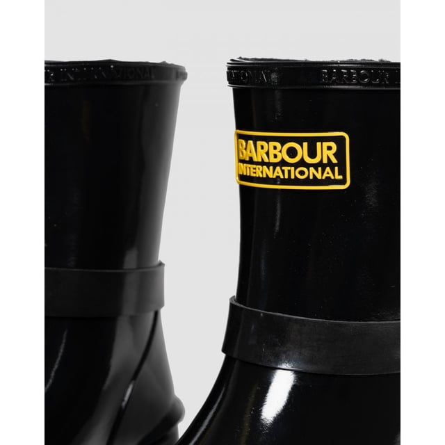 Botas mugello negras Barbour International para mujer, fabricadas en caucho y suela de caucho. Presentan: acabado de alto brillo, suela de perfil bajo, marca Barbour, hebilla decorativa y estilo motero.
