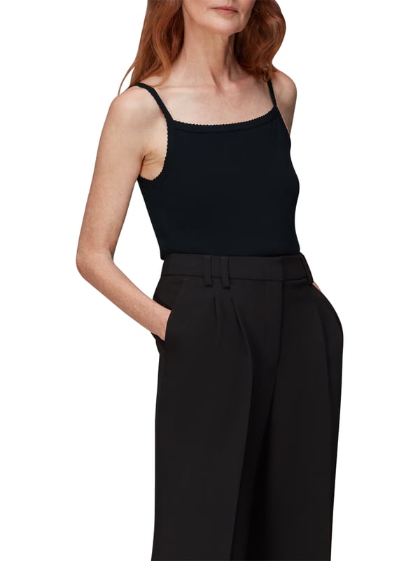 Dress up for comfort with this sleek Scallopped Vest, featuring a soft ribbed material and charming scalloped detailing. A versatile addition to your wardrobe, perfect for layering or as a chic stand-alone piece. Ideal for everyday elegance.