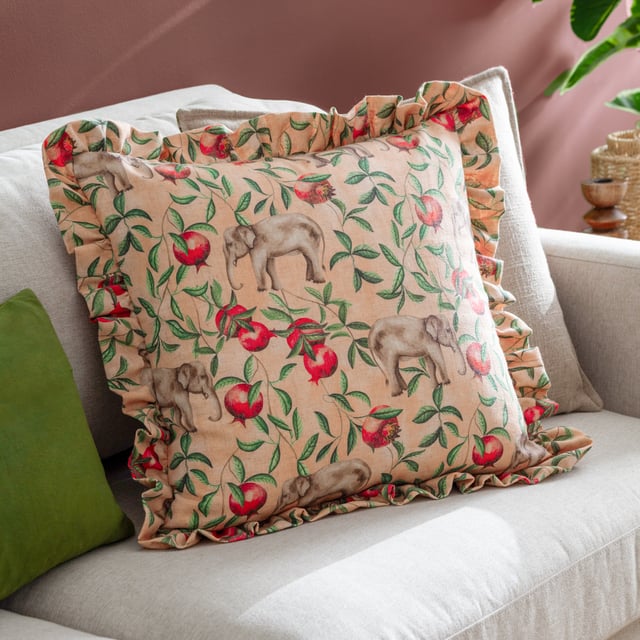 Elevate your interior décor with the Okara Elephant Printed Ruffle Cushion, a statement piece that combines artistry with elegance. Featuring a hand-painted design of elephants and pomegranates, expertly printed onto a linen-blend fabric, this cushion brings the beauty of the natural world into your home. Its textured finish and subtle the harmony of gentle hues complemented by striking accents creates a vibrant aesthetic. Framed by a ruffle trim, it offers a touch of relaxed charm that complements a variety of modern interiors. Perfect for those who value unique prints and quality craftsmanship, this cushion adds effortless style to any space.