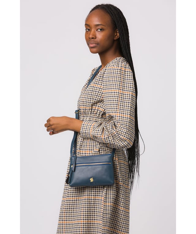 The 'Sweetie' cross body bag from Conkca London is handcrafted from multi-toned leather for a beautiful finish. A zip-over top opens to reveal a spacious yet compact main compartment with two slip pockets, lined with natural and untreated 100% cotton. Features a zipped pocket on the front and a slip pouch on the rear, ideal for on-the-go storage. Comes with an adjustable leather strap with a maximum drop length of 70cm. Adorned with the inimitable Conkca squirrel charm and Conkca logos.