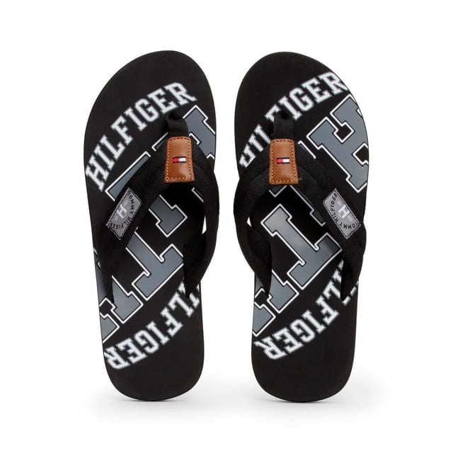Mens Tommy Hilfiger Essential Beach Flip Flops in black.- Synthetic upper.- Slip on design.- Branded retro graphics.- Synthetic lining.- Rubber sole.- Ref.: FM0FM01369990