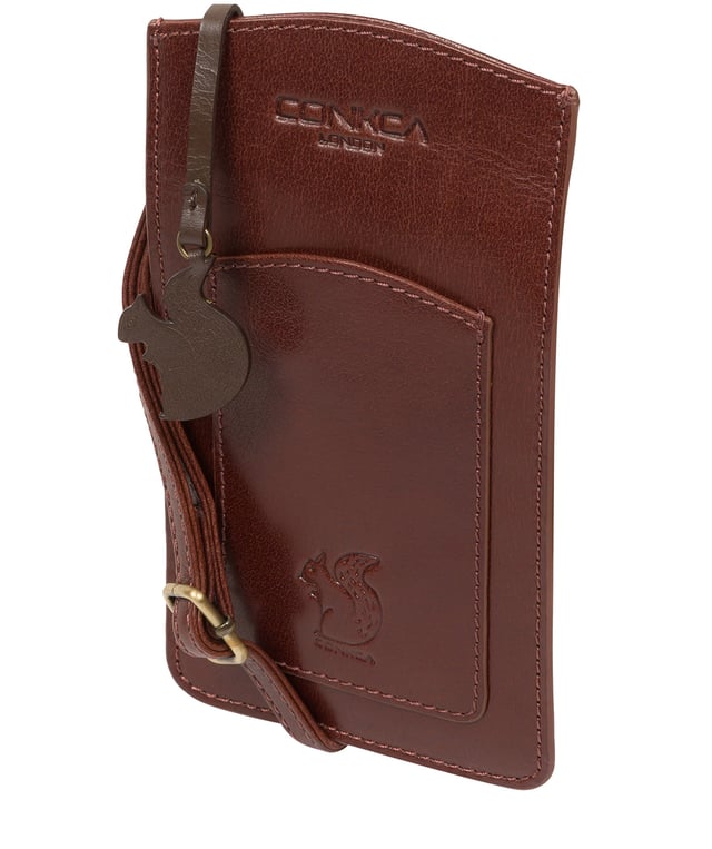 The 'Siren' from Conkca London is handcrafted from genuine leather for a beautiful finish. This open-top phone bag is the perfect way to keep your phone on your person whilst keeping your hands free. The interior is lined with natural and untreated 100% cotton. Includes a cotton-lined slip pouch on the front and two card slots on the rear, ideal for maintaining an organised bag. Comes with an adjustable leather strap with a drop length of 70cm, alongside gold metal fittings. Adorned with the iconic Conkca logo and charm.