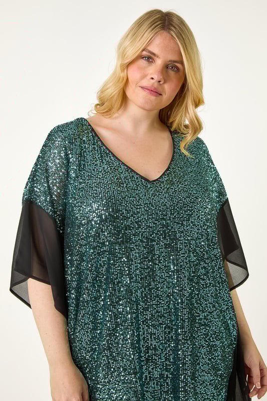 Curve Full Sequin Chiffon Overlay Top from Roman. Unleash your inner glam goddess with the sequin overlay top! This dazzling top features an all over sequin design with a delicate chiffon trim overlay, adding a touch of elegance. The V-Neckline and below hip length create a flattering silhouette that's perfect for special occasions. Pair it with pleather trousers and heeled boots to create a show-stopping party look that will turn heads all night long!