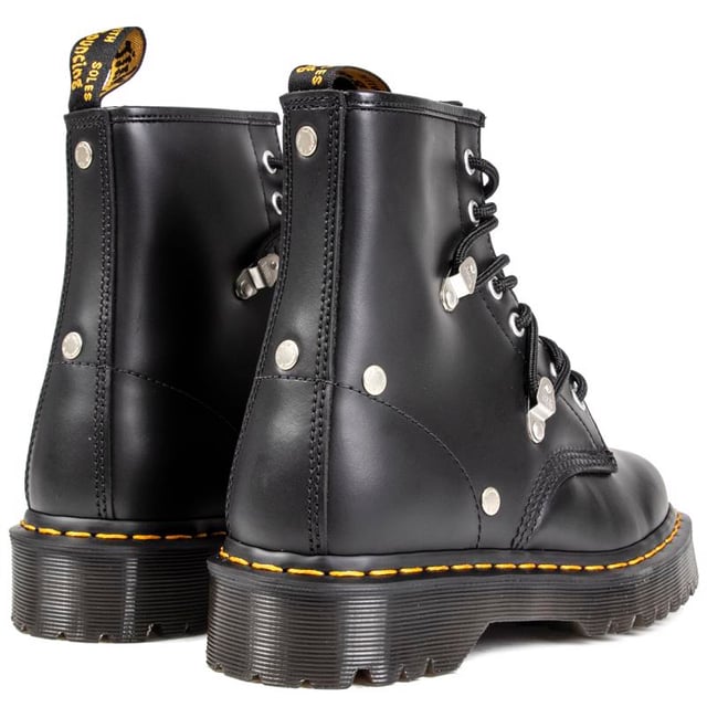 Women's Black Dr. Martens 1460 Pascal Lace-up Boots With A Leather Upper Featuring Standout Metal Studs And Loops Coordinating With 6 Eyelet Lacing System, And Signature Airwair Heel Loop. These Ladies' High-top Boots Have The Iconic Yellow Stitching And Goodyear Welted Air-cushioned Sole With Rugged Tread.