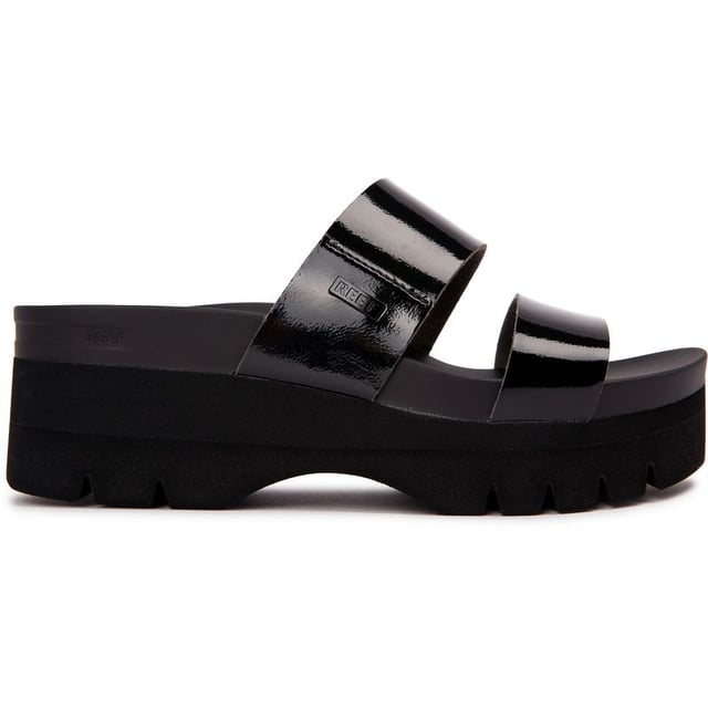 Experimente el lujo con estilo veraniego con las sandalias de plataforma Reef Cushion Vista Higher. La parte superior vegana, la plantilla suave y acolchada y el amplio soporte para el arco brindan a tus pies una pisada cómoda. La suela de plataforma y el talón ofrecen estabilidad y comodidad. Estas sandalias negras brillantes combinan moda y funcionalidad. Mima tus pies con Reef Cushion Vista Hi.
