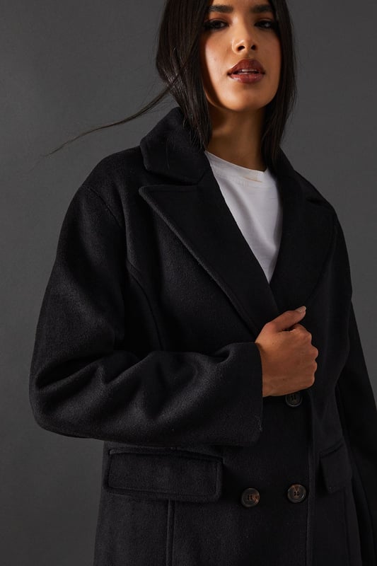 Double-breasted design for a sophisticated silhouette
        Maxi length offering full coverage and dramatic flair
        Wide lapels adding a touch of classic elegance
        Flap pockets for both style and functionality
        Relaxed fit allowing for layering versatility
    
    Make a statement with this striking double-breasted maxi coat from Warehouse. Perfect for the confident woman who appreciates edgy yet feminine style, this coat seamlessly transitions from day to night. The oversized silhouette exudes effortless chic, while the maxi length adds drama to any ensemble. Style it over wide-leg trousers and a chunky knit jumper for a contemporary daytime look. For evening affairs, drape it over a sleek midi dress and pair with heeled boots to create a captivating outfit. The versatile design allows for endless styling possibilities, making it a true wardrobe staple that will serve you well for seasons to come. Whether you're heading to the office or out for dinner, this coat will ensure you arrive in style.