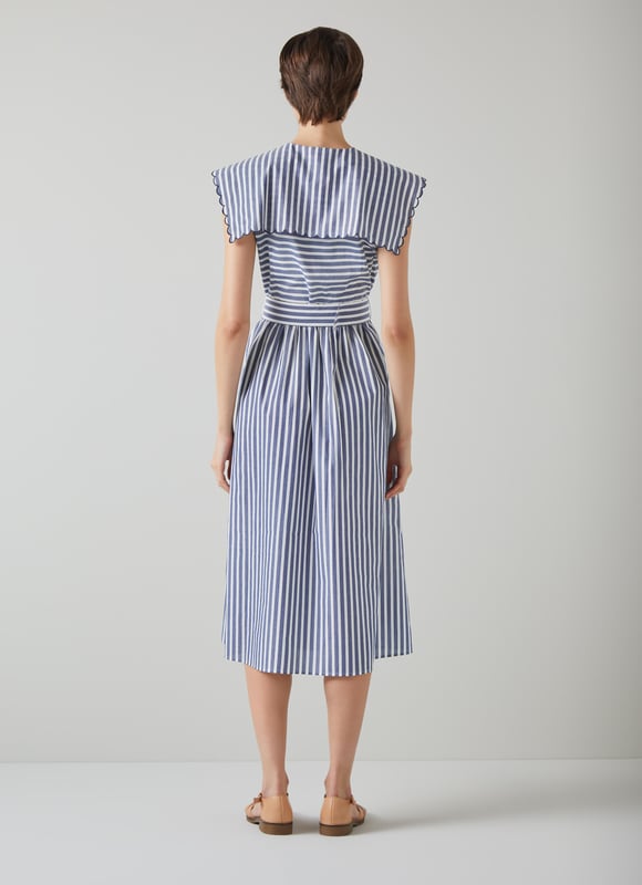 A chic sun dress which takes design cues from sailor style, beautiful Beau is destined for glamorous destinations. It's crafted from blue and cream striped cool cotton, and has a wide scalloped edge collar with tie detail, a fabric-covered buckle belt and an A-line midi skirt. Wear it with a pair of leather sandals and a basket bag.