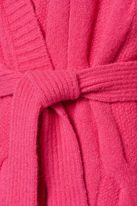 Het Chelsea kabelvest in een zachte roze kleur is een prachtig gebreid, lang vest met een openvallend ontwerp en robuuste ribboorden. Met een relaxte pasvorm die net boven de kuit valt, biedt dit vest een comfortabele en elegante uitstraling. Een afneembaar strikceintuur voegt een vleugje tailleaccentuering toe aan het geheel. Vervaardigd uit een wolmix van 47% acryl, 22% nylon, 20% wol, 8% alpaca en 3% spandex, biedt dit vest warmte en comfort, waardoor het ideaal is voor koude winterdagen. De combinatie van wol en alpaca verleent het vest een zachte en luxueuze textuur, terwijl acryl en nylon zorgen voor duurzaamheid en vormbehoud. De toevoeging van 3% spandex biedt een lichte stretch, wat resulteert in een comfortabele en flexibele pasvorm.Kortom, het lange roze Chelsea vest is een stijlvol en veelzijdig kledingstuk, met zijn losse snit, bijbehorende strikceintuur en prachtig gebreide ontwerp. De combinatie van diverse hoogwaardige materialen garandeert zowel comfort als stijl, waardoor het een uitstekende aanvulling is op je wintergarderobe. Het Chelsea vest biedt talloze mogelijkheden om verschillende stijlvolle en comfortabele outfits te creëren.Een suggestie is om het Chelsea vest te dragen over de Jesper travel top, samen met de Indy travel broek in een opvallende kobaltkleur. Het contrasterende kobaltblauw voegt een levendige dimensie toe aan het roze vest, wat zorgt voor een sprankelende outfit. Je kunt ook het Chelsea lange vest combineren met de Cassidy tuniek in een veelkleurig patroon, samen met de zwarte legging. Het levendige en kleurrijke patroon van de tuniek creëert een boeiend contrast met het effen roze vest. Eveneens kun je het roze kabelvest succesvol combineren met de Audrey print blouse. Onthoud dat jouw comfort en zelfverzekerdheid in je kledingkeuze centraal staan. De combinatie van de roze tint en het sprankelende, veelkleurige patroon geeft je outfit een krachtige en vrolijke uitstraling.