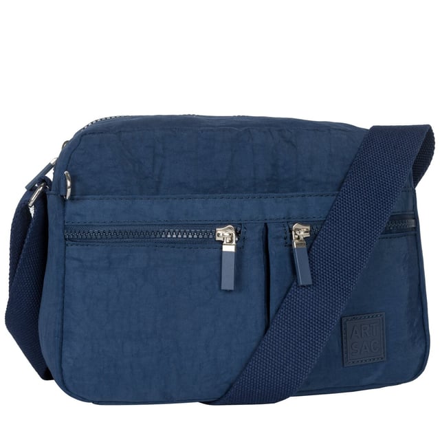 This practical everyday bag is heavy on features and light in weight, with two main zip compartments and a hidden zip on the front flap as well as your main zipped compartment it is more than ideal for organising your valuables. This casual, compact design also features an adjustable cotton strap for all your comfort needs. This functional fun design is stylish and spacious for all your travelling needs, from the supermarket to a Saturday hike. Features: , Artsac rubberised patch logo, Two main zip compartments, Adjustable strap, Concealed front zip section, Front flap-over with 2 zip pockets, Internal zip and slip pocket, External zip pocket on the back Style Ref: 50460 NAVY