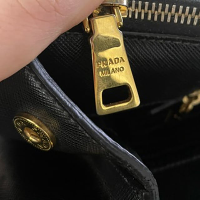 VINTAGE, NEUPREIS WIE NEU  
Die Prada Double Zip Executive Tote Bag aus schwarzem Saffiano Lux Leder ist ein elegantes und vielseitiges Accessoire. Hergestellt aus strapazierfähigem und luxuriösem Saffiano-Leder, vereint diese Tote praktische und stilvolle Eigenschaften und bietet ausreichend Platz für alle Ihre täglichen Essentials und mehr. Mit ihrem schlanken Design und funktionalen Merkmalen, einschließlich zweier Außentaschen mit Reißverschluss und einem großen Hauptfach, ermöglicht diese Tasche eine bequeme Organisation Ihrer Sachen. Abgerundet mit einer schicken Clochette und einem Schlüsselring-Detail ist diese Tasche der perfekte Begleiter für den Alltag und kombiniert mühelos Eleganz und Funktionalität.

Prada Double Zip Executive Tote Bag aus schwarzem Saffiano Lux Leder  
Zustand: Ausgezeichnet  
Abnutzungserscheinungen: Kein Einzelhandelsetikett, keine sichtbaren Gebrauchsspuren,  
Verpackung: Keine  
Farbe: schwarz  
Material: Leder | Saffiano-Leder  
Größe: Einheitsgröße  
Maße: Breite: 180; Höhe: 300; Länge: 420; Henkelabfall: 130; Gurtlänge: 300  
SKU: NAPPUGBBA399031W