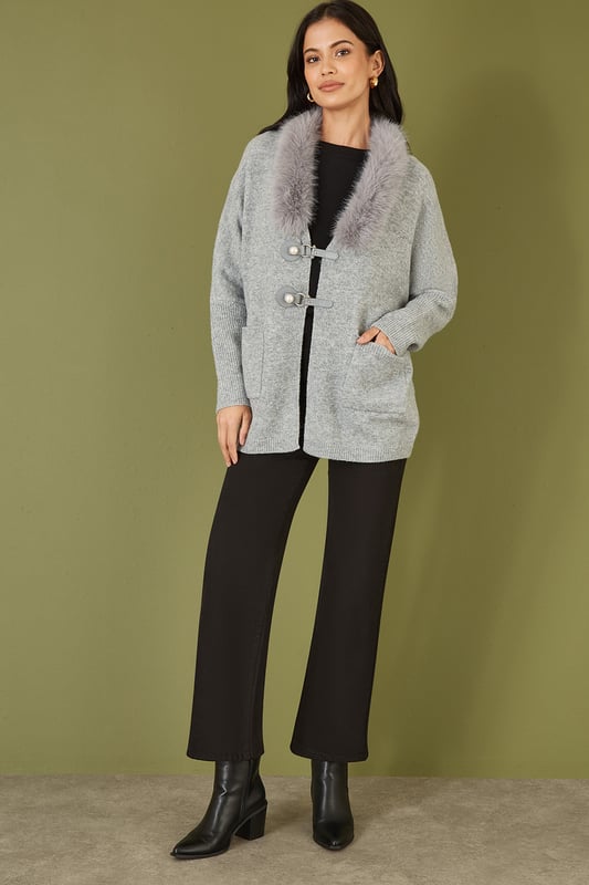 This cute cardi is perfect for cosying up this winter - In a soft marl knit with buckle fastening in the front and faux fur detachable collar. Style with jeans and a roll neck jumper - With boots or trainers for a casual off duty look.