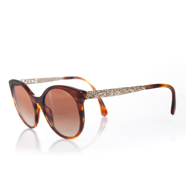 VINTAGE, RRP AS NEW
Chanel, round tortoise sunglasses with metal Chanel cut out temples in gold. The item is in good condition. The lenses have very light scratches and The temples are slightly apart (need adjustment). Comes with case and dust cloth.
 • CONDITION: good

• CODE: 5440

• MEASUREMENTS: height lens 5,5 cm, width lens 6 cm, width frame 14 cm

• MATERIAL: plastic, metal

• COLOR: brown, gold