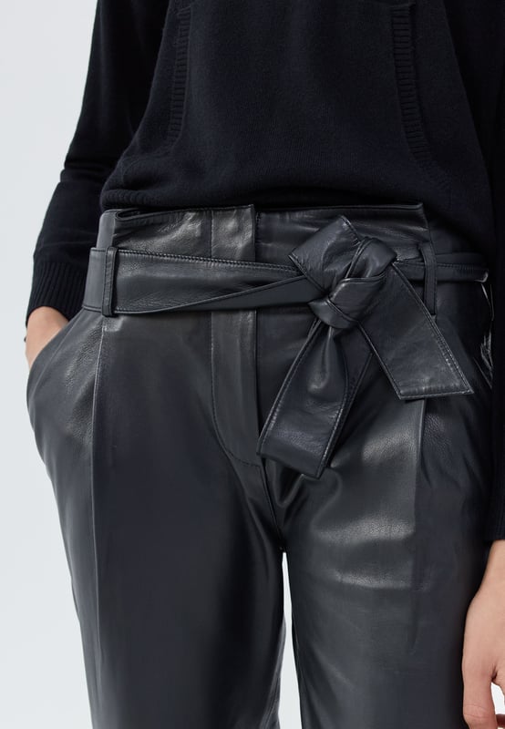 These high-waisted lambskin trousers feature a removable waistband, two side Italian pockets, cut-outs at the knees and slits at the bottom of the leg. Straight leg cut 7/8. Button and zip fastening.