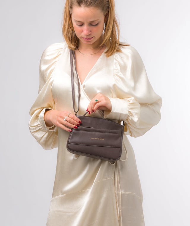 The 'Helena' cross body bag from the Pure Luxuries Marylebone collection is handcrafted from high-quality, genuine Nappa leather with a natural super-soft touch. The zip-over top opens to reveal a 100% cotton-lined interior. The spacious compartment features two slip pockets to help maintain an organised bag. A zipped pocket on the front of the bag provides on-the-go storage. Features gold-coloured metal fittings and zips alongside the adjustable slim leather strap, with a maximum drop length of 65cm. The Pure Luxuries logo is embossed in gold foil for a beautifully simple finishing touch.