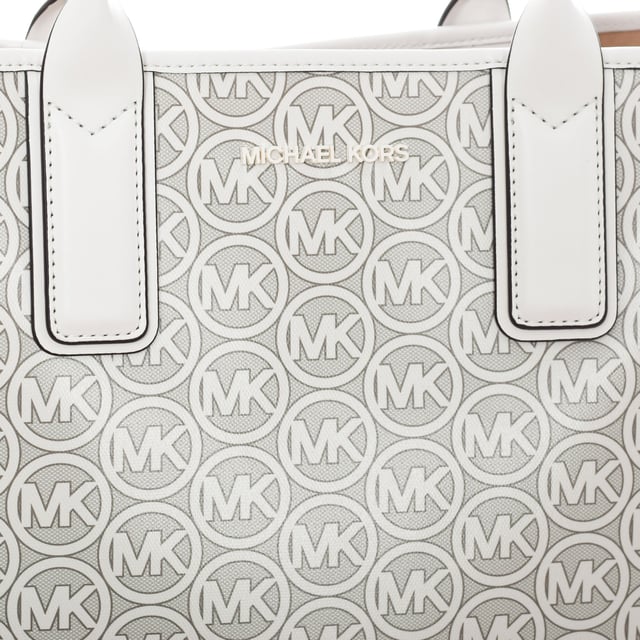 Bolso tote 35H1T2JT3C mujer 

Diseño y Forma:
- Este bolso Michael Kors tiene una silueta clásica de estilo tote.
- Presenta una forma rectangular y estructura rígida para mantener la forma.

Asas:
- Cuenta con asas de mano largas para llevar el bolso cómodamente en el brazo.
- Las asas están diseñadas para soportar el peso del bolso lleno.

Cierre:
- No tiene cierre.

Detalles de la marca:
- Tiene el logotipo de la marca Michael Kors grabado en el frontal.

Características:
- No tiene bolsillos internos.
 Medidas: 45x30x16cm
 Composición: 100% PVC
 Cuidados:
Limpiar con un paño húmedo.