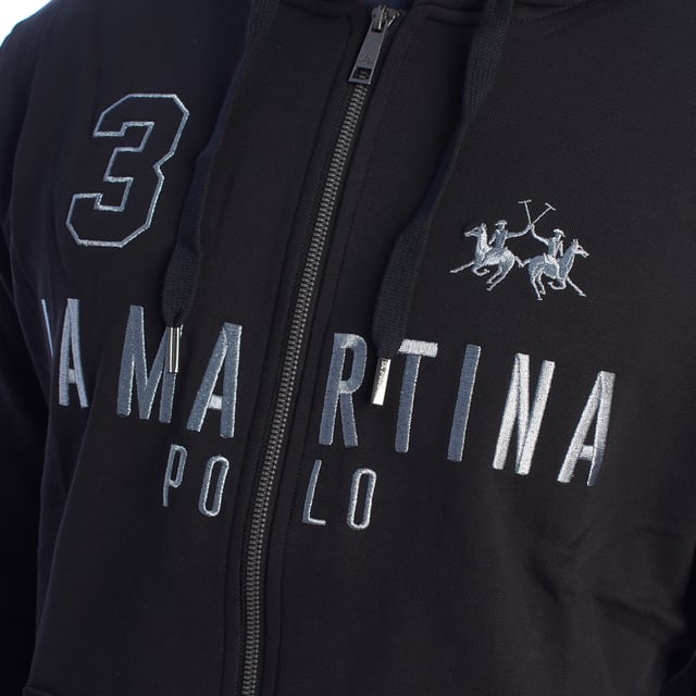 Sudadera con capucha y cremallera La Martina.

Un clásico imprescindible para los días más frescos. Esta sudadera con capucha y cremallera de La Martina combina diseño deportivo con detalles elegantes, convirtiéndola en una prenda perfecta para un estilo casual con toques sofisticados.

Detalles:

- Confeccionada en algodón suave de alta calidad.
- Capucha ajustable con cordones.
- Cierre frontal completo con cremallera metálica resistente.
- Bolsillos estilo canguro.
- Detalles bordados y estampados con el logotipo y emblemas de La Martina.
- Puños y dobladillo en punto acanalado.

Con un diseño que combina comodidad, calidad y detalles exclusivos, esta sudadera con capucha de La Martina es una elección versátil que complementará cualquier estilo casual.
 Composición: 100% Algodón
 Cuidados:
- Lavar a máquina a una temperatura máxima de 30°C.
- Utilizar detergente suave.
- No usar lejía ni blanqueadores.
- Secar a baja temperatura.
- Planchar a temperatura media por el reverso.