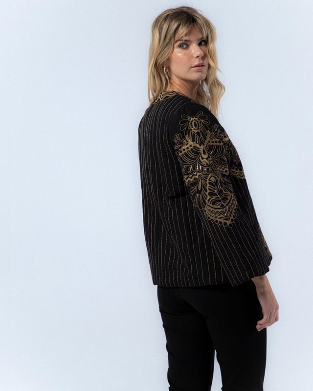La Chaqueta Diana es una pieza clave para tu armario de otoño. Con su elegante diseño bordado y corte holgado, esta chaqueta ofrece un estilo sofisticado y moderno. Combínala con pantalones oscuros y tacones para un look chic y profesional.
 
 
 
 Chaqueta acolchada con cuello redondo.
 
 Manga larga.
 
 Bordado a máquina y a mano en delantero, espalda y mangas.