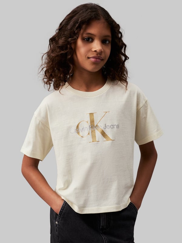 Introducing the Girls Glitter Monogram Boxy T-Shirt in Ivory by Calvin Klein Jeans, a quintessential piece for AW2024. Luxuriously tailored for the discerning young lady, this t-shirt blends elegance with a dash of playfulness. Key features include: **Chic Monogram Design**: Embellished with glittering Calvin Klein monogram for a touch of glamour. **Premium Quality Fabric**: Crafted from the finest materials for unmatched comfort and durability. **Versatile Ivory Shade**: A timeless hue that complements any outfit effortlessly. Elevate her wardrobe with this exquisite garment today!
