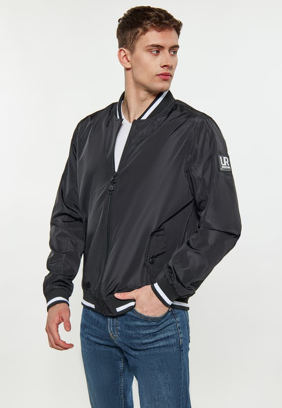 Een bomberjack voor wie op zoek is naar een perfecte mix van stijl en functionaliteit. Deze jas heeft een ritssluiting aan de voorkant die loopt van de onderkant tot aan de kraag voor een veilige pasvorm. De geribbelde structuur bij de kraag zorgt voor een extra vleugje verfijning en wordt aangevuld met contrasterende streepdetails. De geribde elastische banden bij de manchetten en onderzoom zijn vervaardigd met oog voor detail en hebben bijpassende strepen voor een samenhangende look. Met twee voorzakken met knoopsluiting biedt deze jas handige opbergmogelijkheden zonder dat dit ten koste gaat van de stijl. De ingezette mouwen en de normale schoudernaad zorgen voor een comfortabele pasvorm  college jack