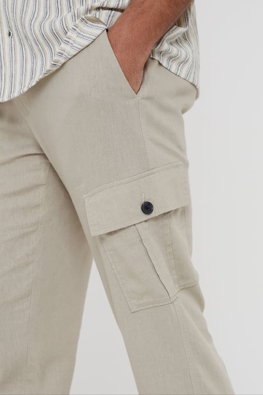 Upgrade your wardrobe with these linen blend cargo trousers from Threadbare. These linen mix cargos are the perfect blend of comfort and style, and with a part elasticated waistband with drawcords, they hit the laidback luxe trend with ease. Cut in a regular fit with a twin needle stitched hem, belt loops, mock horn button and zip fly closure. Linen-rich, these trousers will keep you cool and comfortable all day long, and have two side pockets, two back pockets, along with a button closure pocket on each leg. Team with a casual shirt to complete the look.