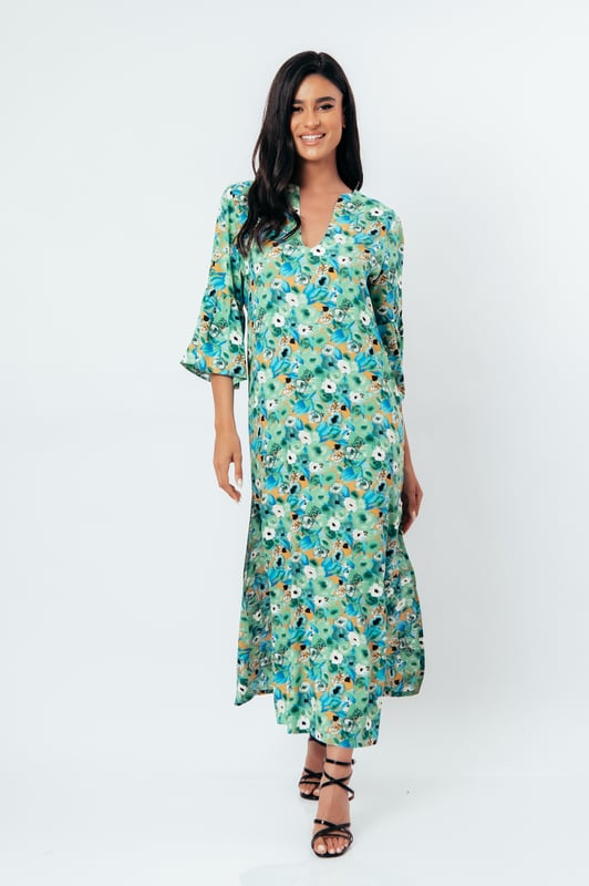 Deze zomerjurk in kaftanstijl met bloemenprint is gemaakt van geweven viscose. Het heeft een mandarijnkraag en een V-halslijn. De mouwen zijn lang met ruches aan de manchetten. De zoom heeft grote zijsplitten. Deze jurk heeft een lang, los, recht silhouet.