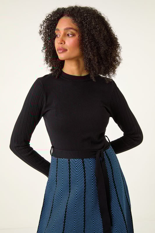 Chevron Print Belted Jumper Dress from Roman. Upgrade your daytime wardrobe with this elegant knee-length, knitted dress. Cut from a soft knitted fabric this dress features a modest round neckline and cosy full-length sleeves. A printed, panelled contrast skirt falls to a fun knee-length in a flattering fit and flare style. A self-tie fabric belt adds shape at the waist if desired while its pull-on style makes for quick and easy dressing. Pair with tights, boots and a fluffy gilet for a cute and casual everyday style!