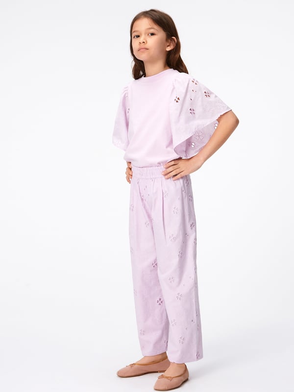 Molo project fun and creative energy into their flawless constructions. These girls floral print alpine glow trousers  are in a broderie anglaise quality both French inspired and divine. They come in organic cotton with an elastic waist and a pleat in the front to emphasise the design on a greater level.  Lining in Same Colour 100% Organic Cotton GOTS Organic Certified By Ecocert Greenlif