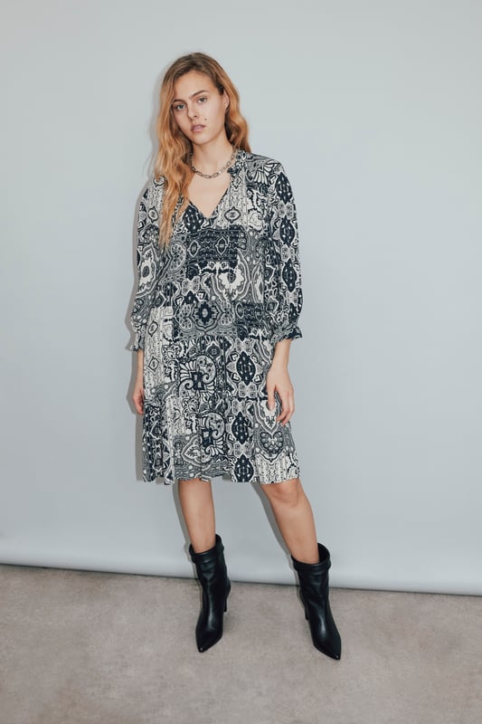 Midi dress with scarf print, round neck, 3/4 sleeves. Sewing at the level of the size. Elastic on the wrists. Tie fastening at the front of the neck and zip on the side.