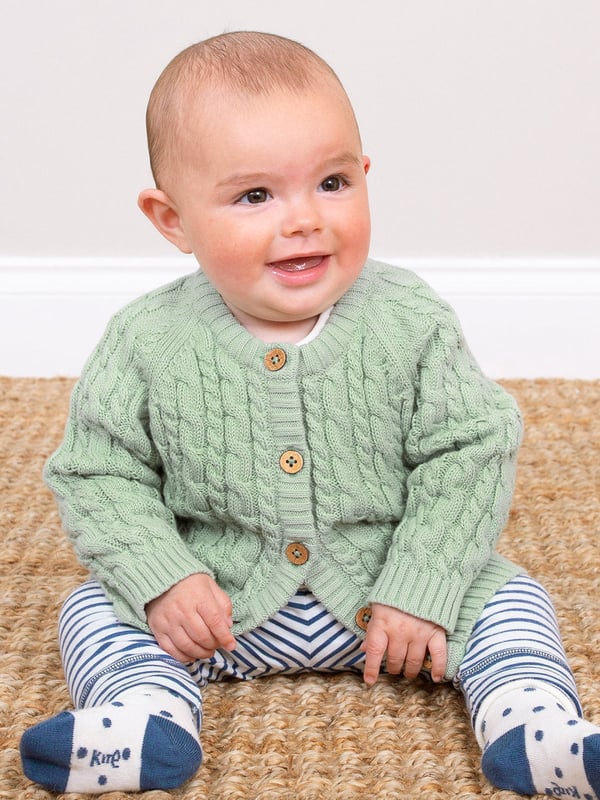 100% organic cotton | Proud to be certified to the Global Organic Textile Standard (GOTS) | Sage green | Midweight 7-gauge cable knit | Coconut button fastening | Long sleeved | Round neck | Rib cuffs and hem | Made in India | Machine washable at 40 degrees, or at 30 degrees to be kinder to the planet