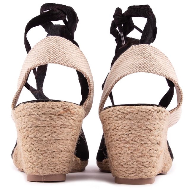 Dale un toque final a tu estilo veraniego con esta cómoda sandalia cuña que fusiona con un zapato de tacón de Solesister. El tacón de yute estilo alpargata se combina con una parte superior en negro y natural, mostrando finos tirantes alrededor del tobillo y un ajuste más amplio. La adición perfecta a tus looks para climas cálidos.