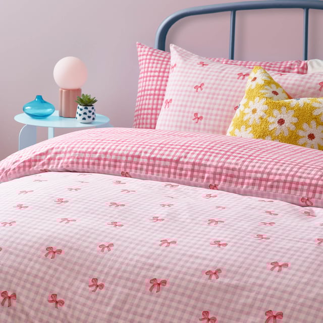 Brighten up your bedroom with the Gingham Bows Checked Duvet Cover Set, a perfect blend of classic charm and contemporary playfulness. Featuring a timeless gingham pattern adorned with delicate bows, this set adds a subtle yet striking detail to your space. The reversible design, with a small-scale check on the reverse side, offers effortless versatility, giving you two stylish looks in one. Crafted from a durable polycotton blend, it promises a soft touch, easy care, and a relaxed finish. Elevate your home with a piece that combines trending design with timeless charm, perfect for creating a cosy yet refined retreat.