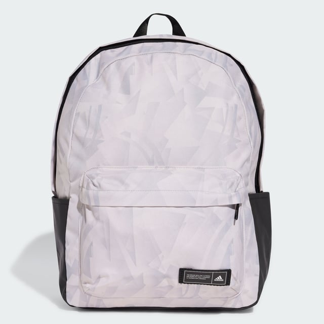 A classic pack with an edgy look. This adidas backpack lends fresh attitude to your casual outfits thanks to a cool allover print. Roomy enough for all your essential gear, it has a zip main compartment, front zip pocket and side slip-in pockets to keep everything organised. Padded adjustable straps add comfort if the bag gets heavy. This product is made with at least 50% recycled materials. By reusing materials that have already been created, adidas help to reduce waste and our reliance on finite resources and reduce the footprint of the products adidas make.  - Dimensions: 15 cm x 36 cm x 44 cm - Volume: 27.5 L - 100% polyester (recycled) - Zip main compartment - Front zip pocket - Side slip-in pockets - Padded adjustable straps  Shipped by adidas