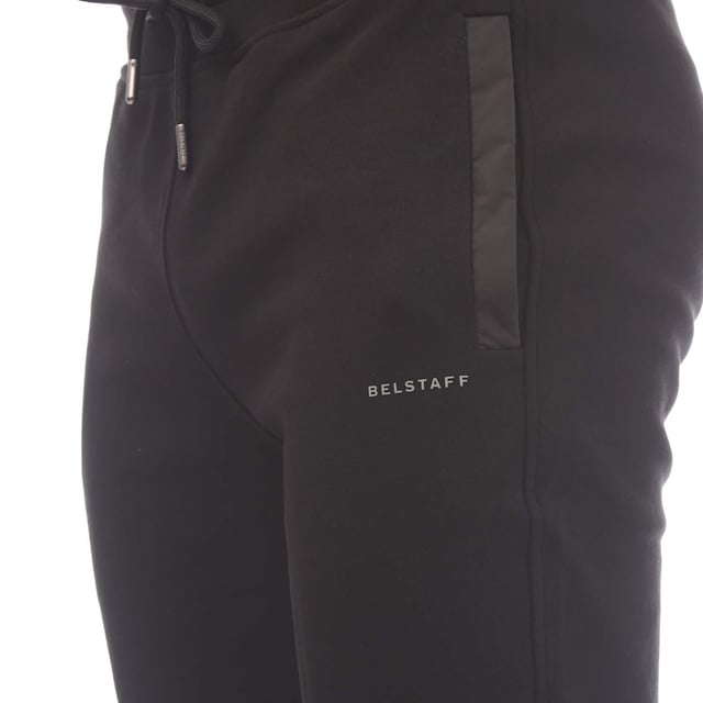 Mens Belstaff Cotton Fleece Alloy Sweatpants in black.- Waist channel drawcord.- Side seam pockets.- Back welt pocket.- Silicone Belstaff logo on left front.- Gunmetal hardware.- A compact double face knitted interlock sweatshirt fabric with technical shell trims.- Regular fit.- 100% Cotton.- Ref: 105241BLACK