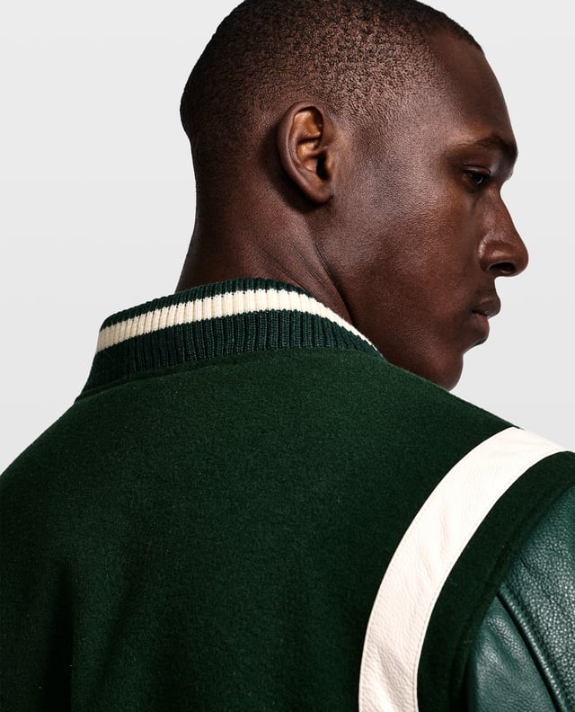 Een ultra high-end varsity jack. Een echte moderne klassieker die altijd in stijl blijft. De jas is gemaakt van schapenwol en de mouwen van eersteklas rundleer. Aan beide kanten zitten ritszakken. Het jack sluit aan de voorkant met een rits en kan verder worden vastgezet met drukknopen.