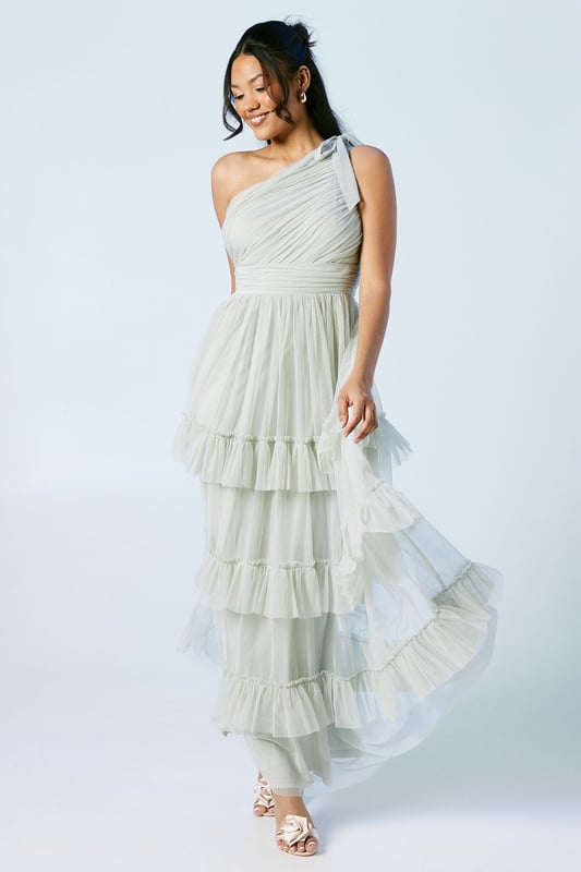 Elegant one-shoulder neckline with pleated detail
        Tiered mesh skirt for a romantic, flowing silhouette
        Floor-length design perfect for formal occasions
        Fitted waistline to accentuate your figure
        Delicate mesh fabric for a light and airy feel
    
    This stunning bridesmaids dress from Oasis is the epitome of grace and sophistication. The one-shoulder neckline adds a touch of modern elegance, while the pleated bodice creates a flattering silhouette. The tiered mesh skirt cascades beautifully to the floor, creating movement and drama with every step. Perfect for your role in the bridal party, this dress will ensure you look and feel fabulous throughout the wedding celebrations. Style with delicate drop earrings and a simple bracelet to complement the dress's intricate design. For a cohesive bridal party look, coordinate with your fellow bridesmaids by choosing matching or complementary accessories. Complete the ensemble with strappy heels and a small clutch bag to hold your essentials. This versatile dress will make you feel confident and radiant as you support the bride on her special day.