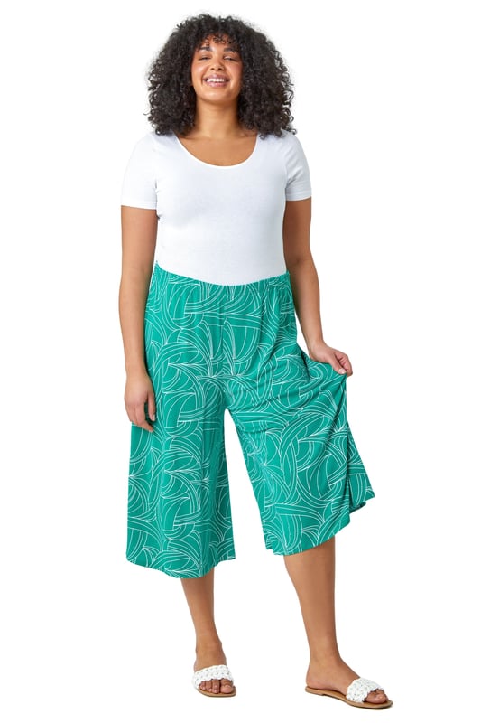 Curve Abstract Swirl Stretch Cropped Culottes from Roman. Say hello to your new favourite staple piece in a bold abstract print. Roman Curve's new and stylish wide-leg culottes are everything you need. Soft stretchy jersey fabric and an elasticated waist make these floaty trousers comfortable and wearable throughout the season. Our casual pull-on bottoms are so versatile, wear with our matching top (19292234) for a striking daytime style.