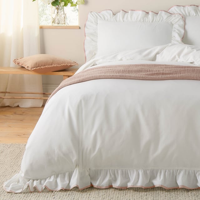 The Blousey Duvet Cover Set offers a simple yet elegant aesthetic, featuring a plain design crafted from soft, 100% cotton sateen. The look is elevated by a delicate ruffle trim and a contrasting piped edge, adding subtle sophistication. Perfect for layering with textured throws and cushions, this set creates a cosy yet fresh look.
