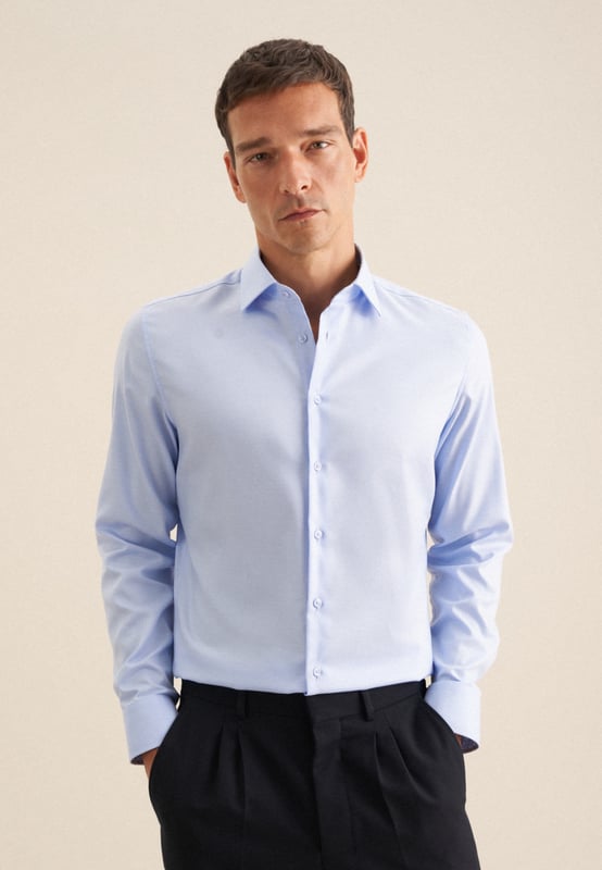 Maskuline Ästhetik: Das blickdichte Business Hemd von Seidensticker aus der "SMART CLASSICS" Kollektion erweitert Ihre Garderobe um einen hochwertigen Look, der den Geist der Zeit trifft. Es ist ein vielseitiger Begleiter, der sich ideal für Büro, Homeoffice oder Veranstaltungen eignet und überall überzeugt. Twill wird besonders hochwertig gewebt. In Kombination mit 100% Baumwolle ist es bequem zu tragen und mit schräg umlaufender Struktur sehr griffig. Die schmale Silhouette dieses Business Hemds in der Passform Shaped betont Ihre Figur ohne dabei zu eng anzuliegen. Dieses Hemd verkörpert zeitlose Eleganz mit modernem Schliff. Stilsicher und elegant liegen Sie mit diesem Langarm-Business Hemd stets richtig. Weitenverstellbare Manschetten ergänzen das klassische Gesamtbild. Hervorragend unterstrichen wird der universelle Business-Charakter durch einen Kentkragen.