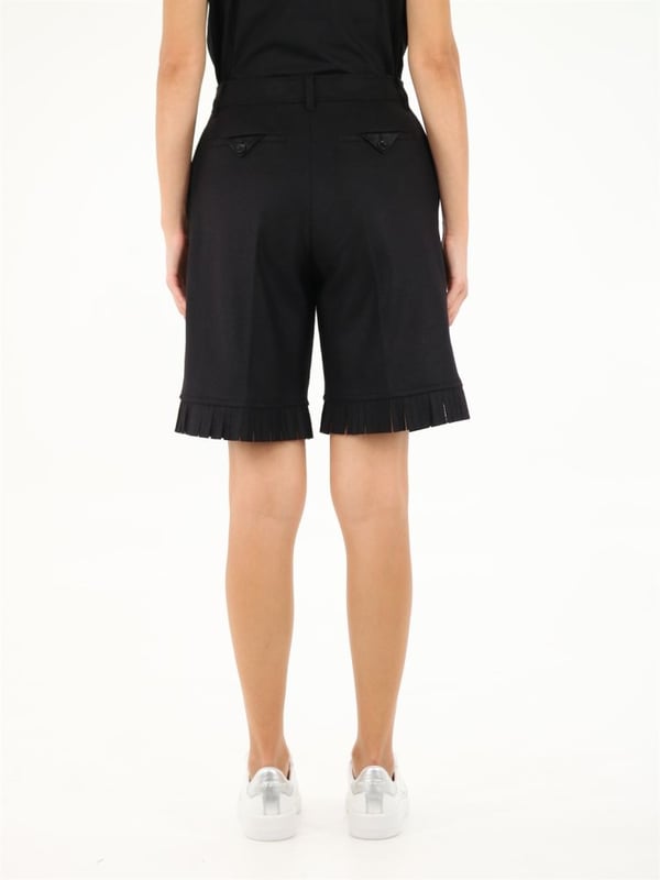 Black shorts made of wool with fringed hem detail. They feature two side pockets, front zip and button closure, belt loops and two back pockets.The model is 178 cm tall and wears a size 6/38 IT